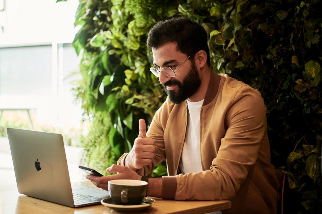 Business owner on computer with thumbs up